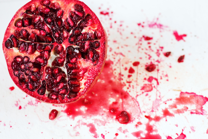 Sliced pomegranate with splashing background